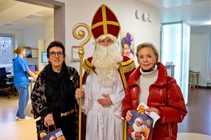 Zwei Frauen umringen den Nikolaus