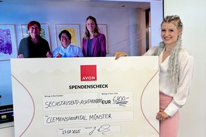 Eine Frau hält einen großen Scheck