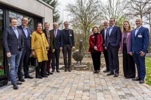 Mehrere Personen stehen um eine Pelikanhaus-Skulptur herum